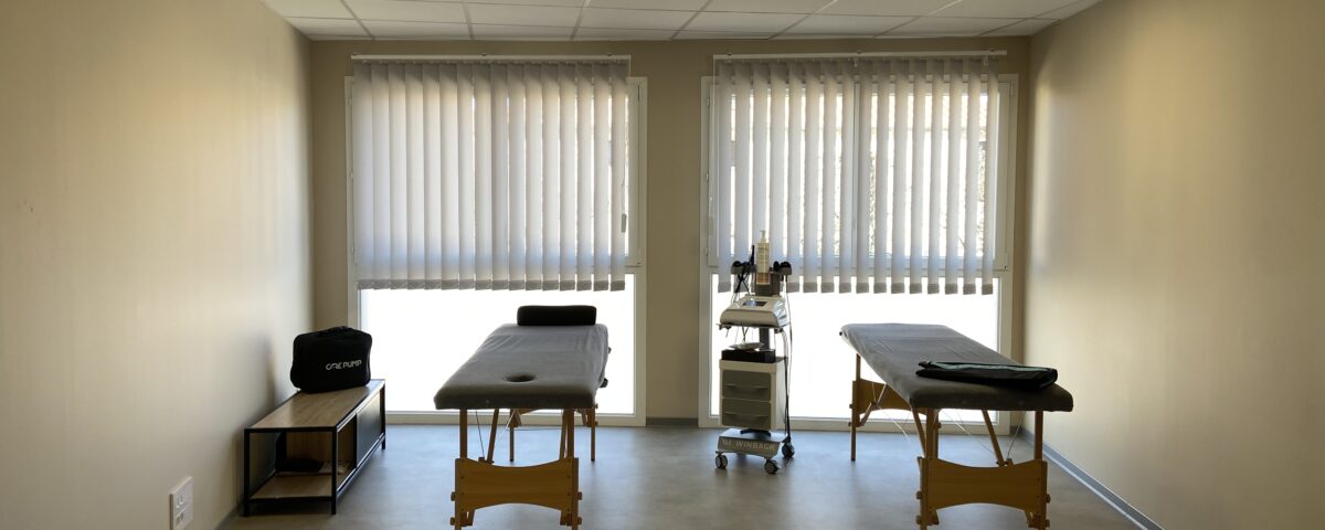 Photographie d'une salle de centre paramédical avec deux matelas de kinésithérapie