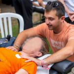 Un ostéopathe effectuant un massage sur une personne allongée, en extérieur