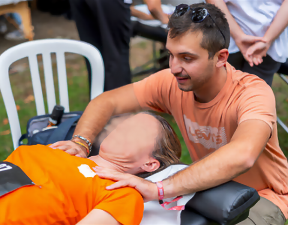 Un ostéopathe effectuant un massage sur une personne allongée, en extérieur
