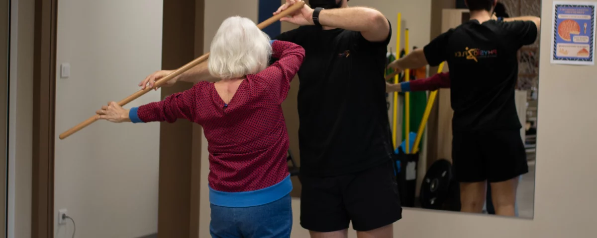 Kiné faisant faire des exercices à une personne âgée