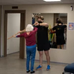 Kiné faisant faire des exercices à une personne âgée