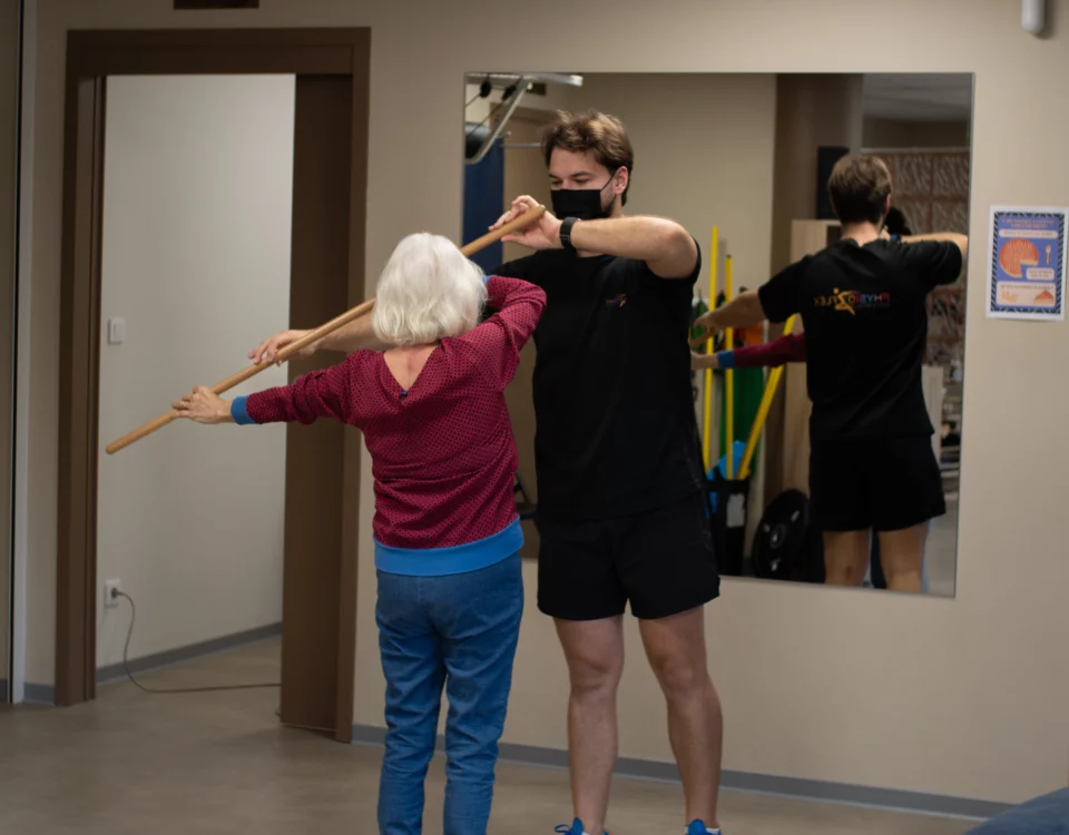 Kiné faisant faire des exercices à une personne âgée