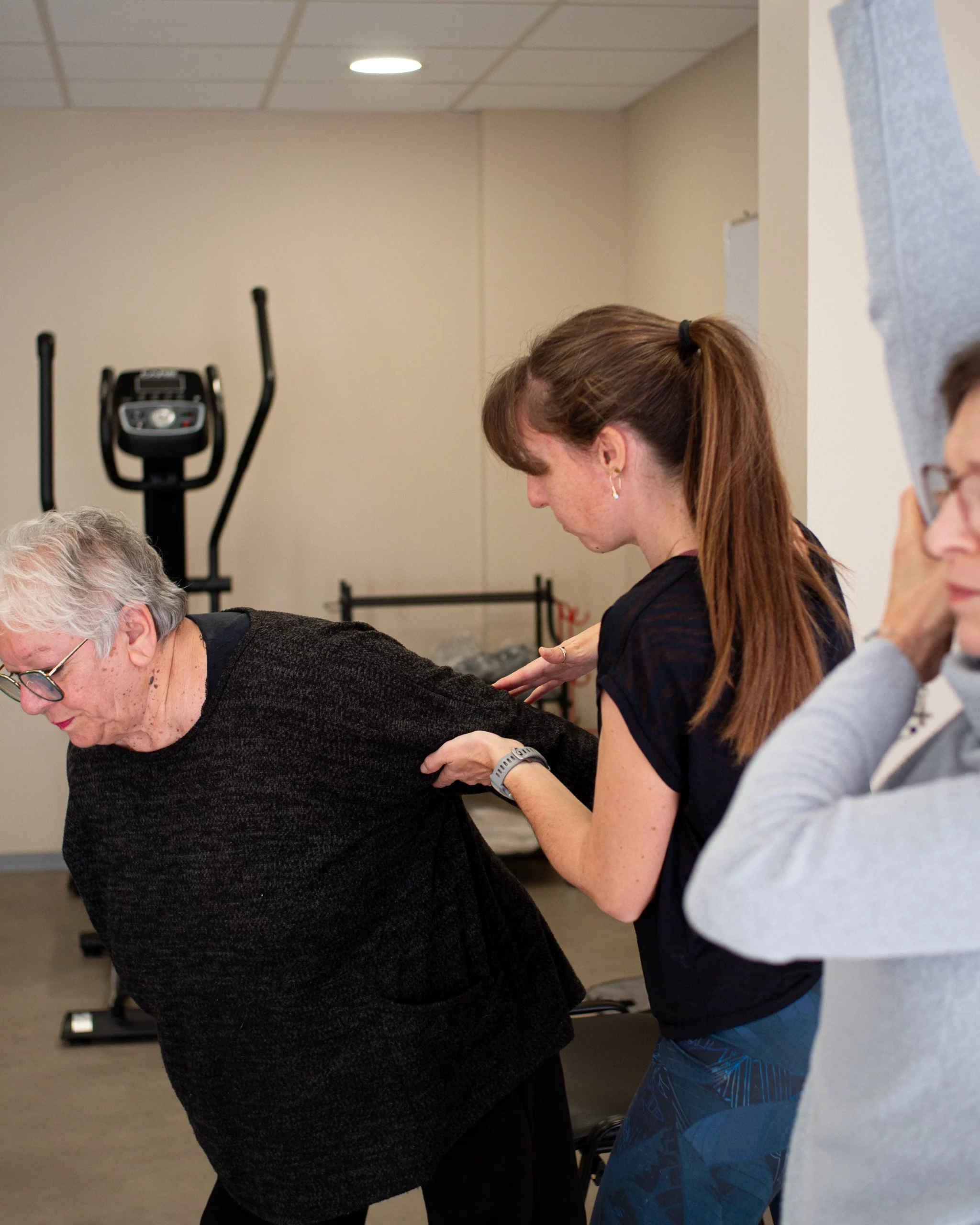 Une femme aidant une personne âgée à effectuer un exercice de musculation