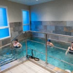 Trois personnes faisant une séance de sport dans une piscine de balnéothérapie